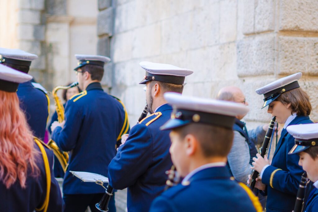 Une fanfare en uniforme joue le long d'un mur