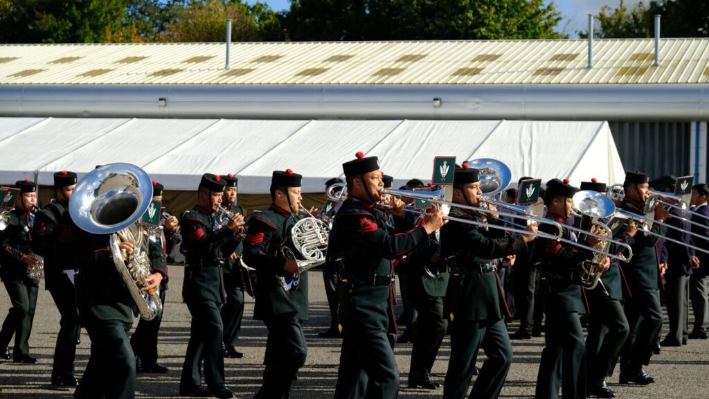 Une fanfare en uniforme défile avec ses cuivres