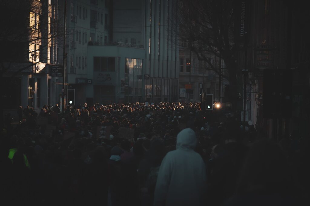 Une foule dans une rue au crépuscule, sous les lumières