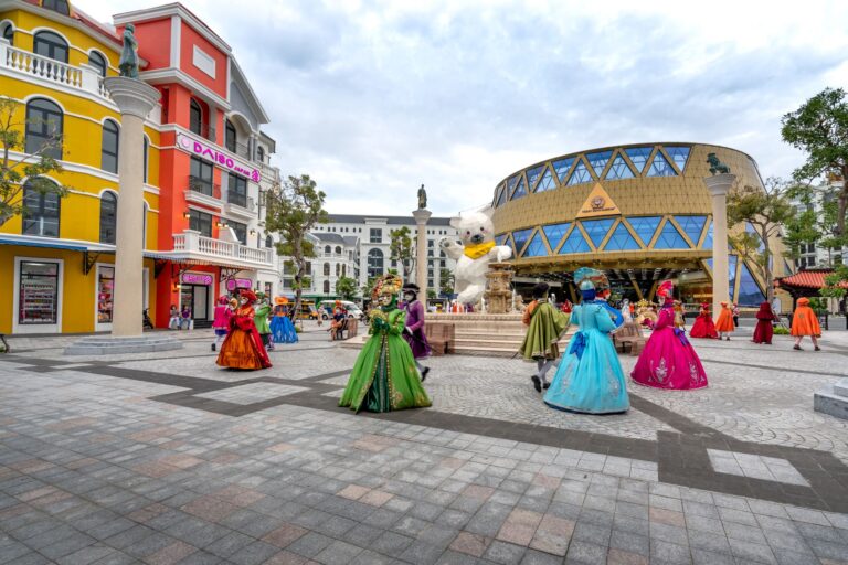 Des artistes costumés jouent sur une place entourée de façades colorées